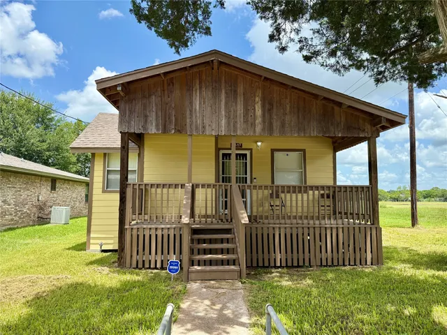 a view of a small house with wooden fence