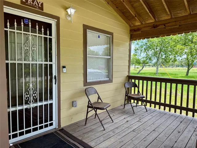 a view of a balcony with chairs and wooden floor