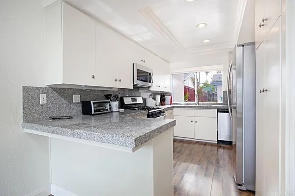 a kitchen with stainless steel appliances granite countertop a sink refrigerator and microwave