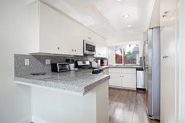 a kitchen with stainless steel appliances granite countertop a sink refrigerator and microwave