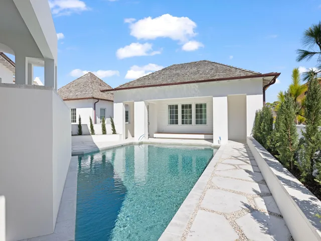 a view of an empty room with wooden floor and a ceiling fan
