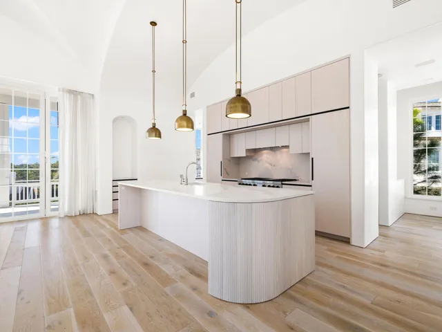 a kitchen with stainless steel appliances granite countertop white cabinets and a wooden floor