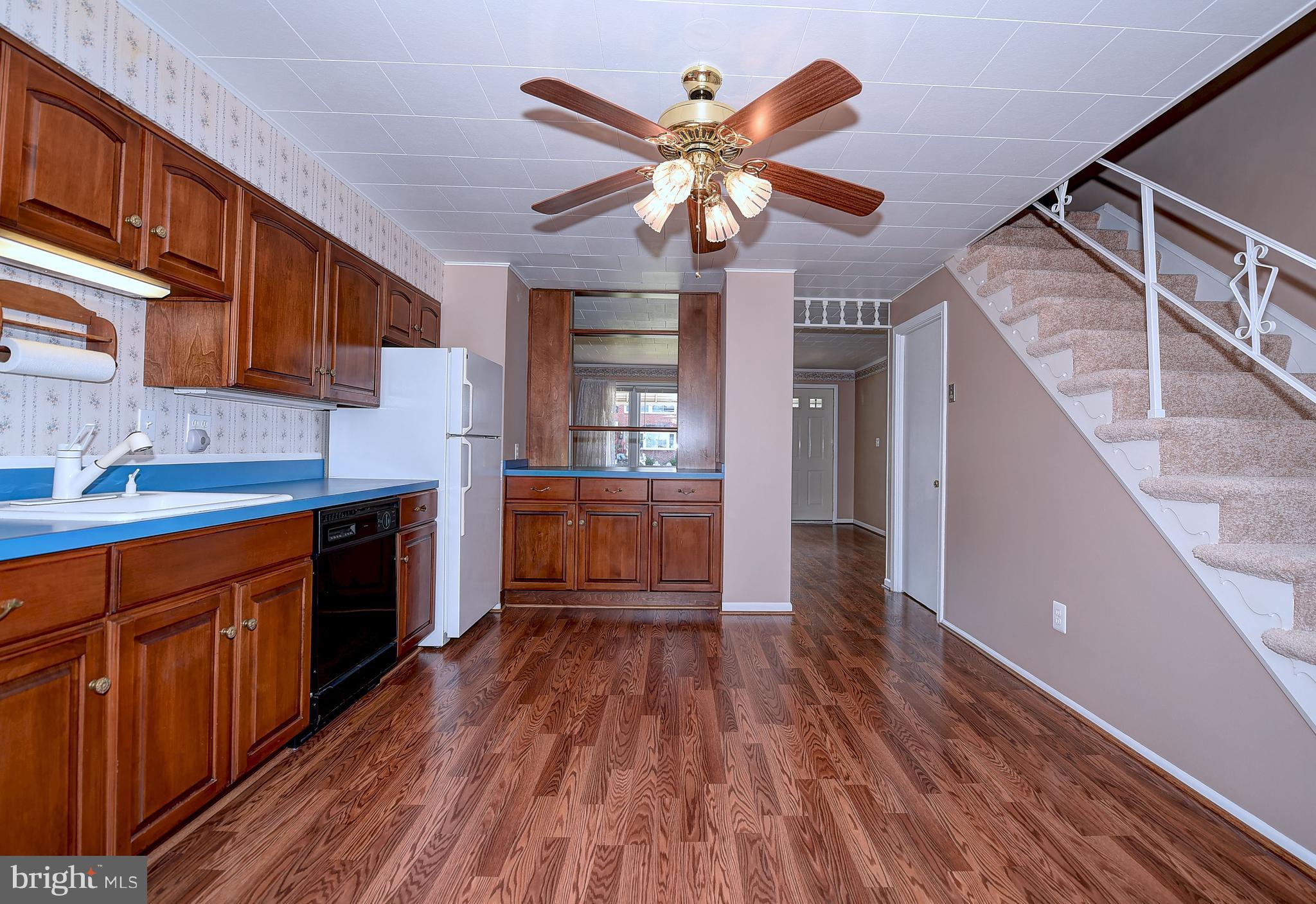8108 Mid Haven Road Baltimore, MD 21222 - Photo 11 of 28 a kitchen with kitchen island wooden floors appliances and cabinets