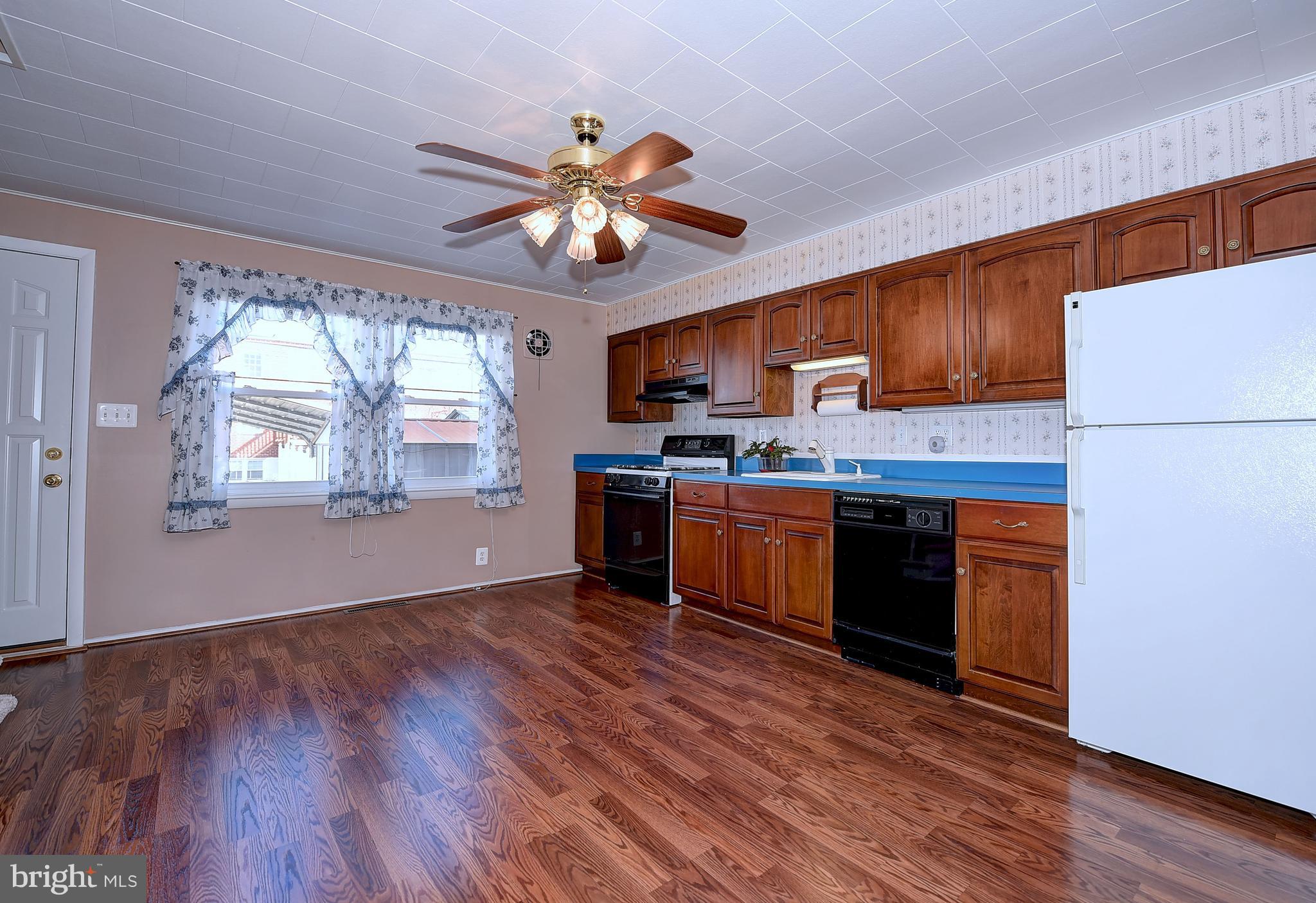 8108 Mid Haven Road Baltimore, MD 21222 - Photo 12 of 28 a kitchen with stainless steel appliances granite countertop wooden floors and white cabinets