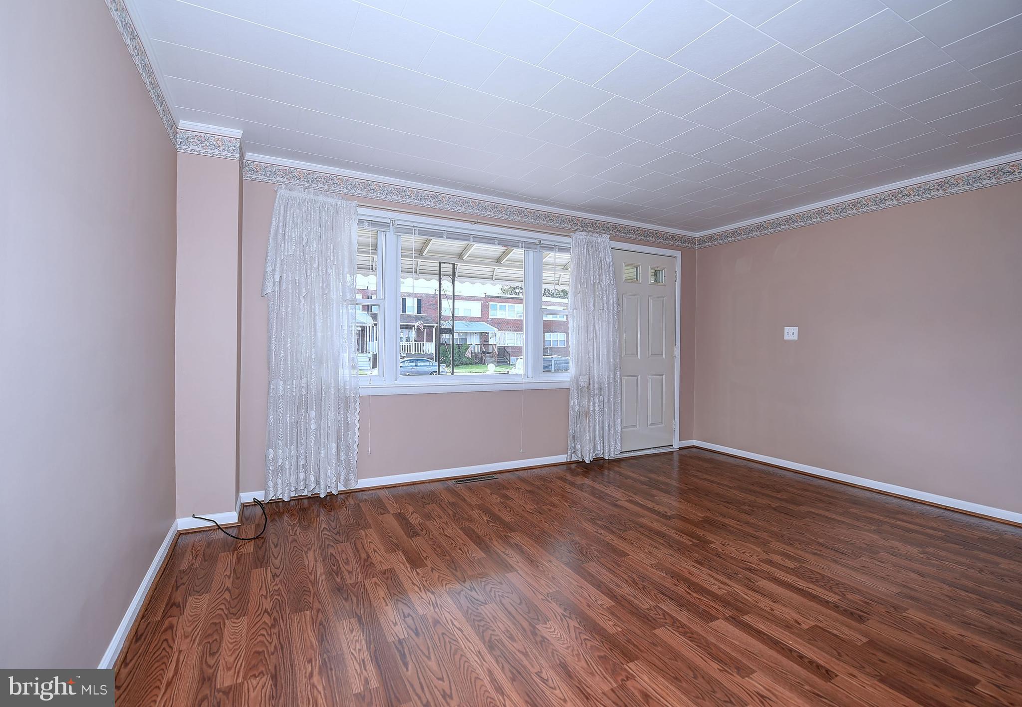 8108 Mid Haven Road Baltimore, MD 21222 - Photo 4 of 28 a view of an empty room with wooden floor and a window