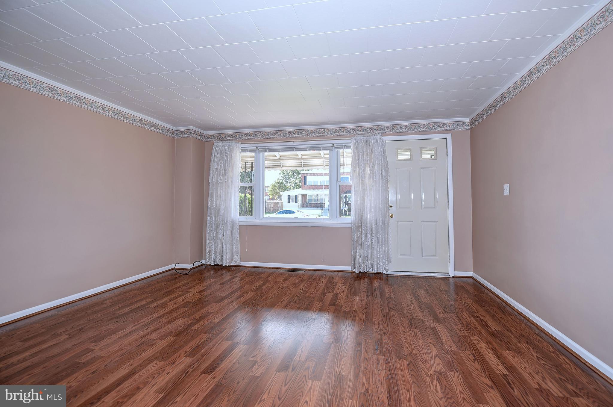 8108 Mid Haven Road Baltimore, MD 21222 - Photo 6 of 28 a view of an empty room with wooden floor and a window