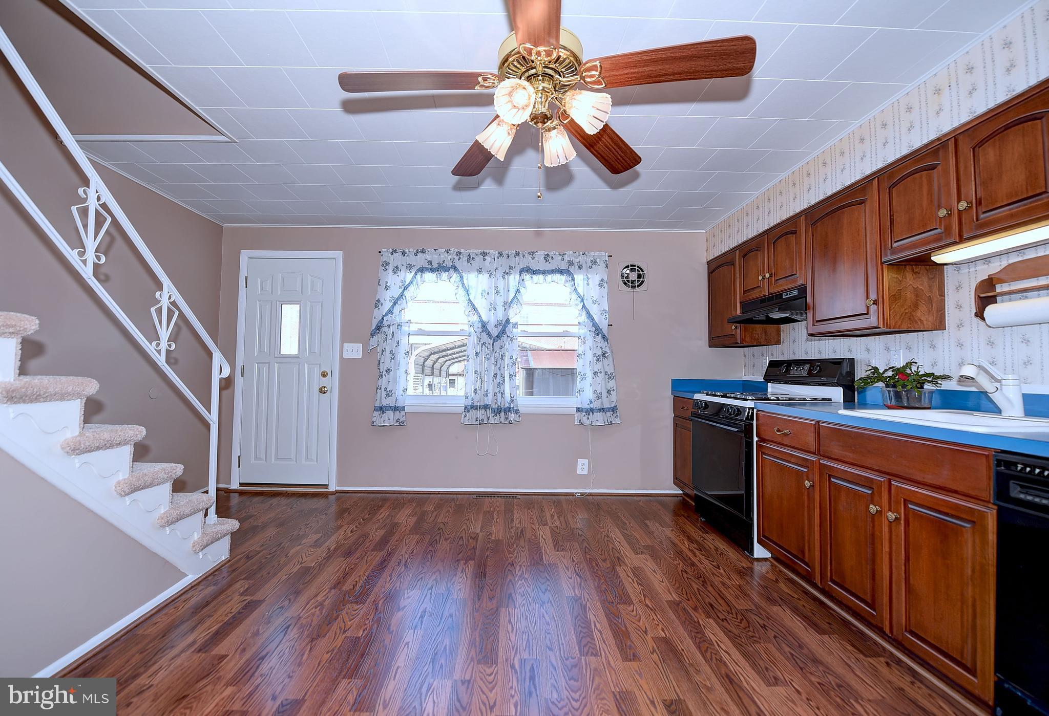 8108 Mid Haven Road Baltimore, MD 21222 - Photo 7 of 28 a kitchen with wooden floors and a view of living room