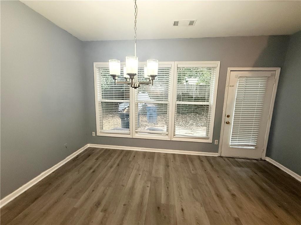2443 Walnut Tree Lane Buford, GA 30519 - Photo 6 of 15 an empty room with wooden floor wooden floor and windows