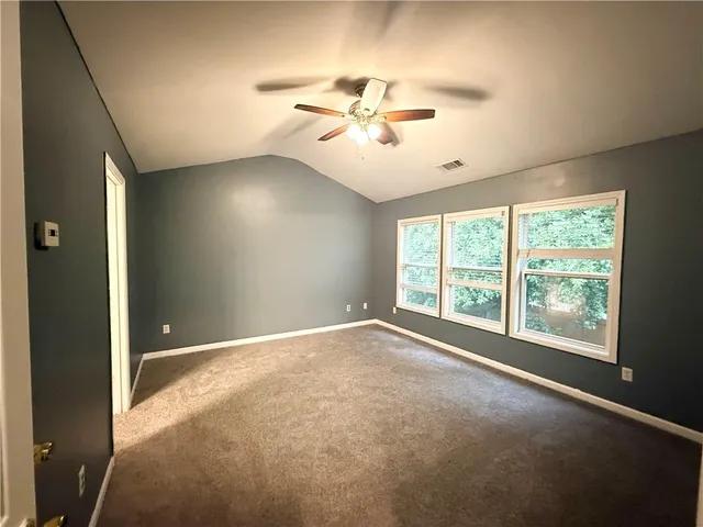an empty room with windows and fan