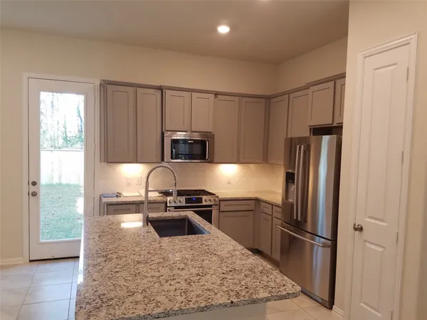 a kitchen with stainless steel appliances granite countertop a refrigerator stove and sink