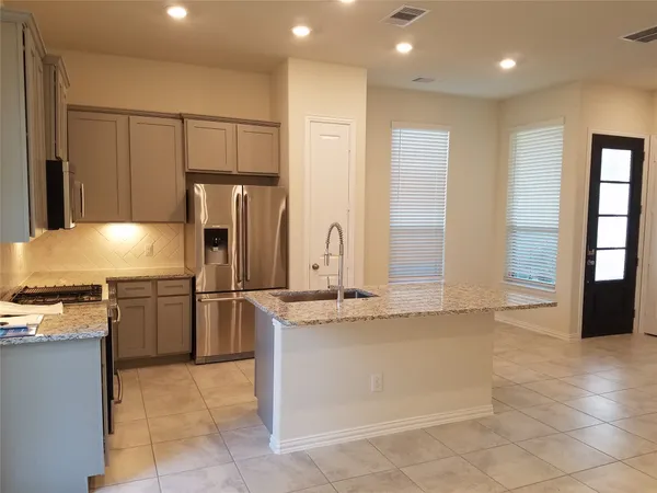 a kitchen with stainless steel appliances granite countertop a refrigerator and a stove