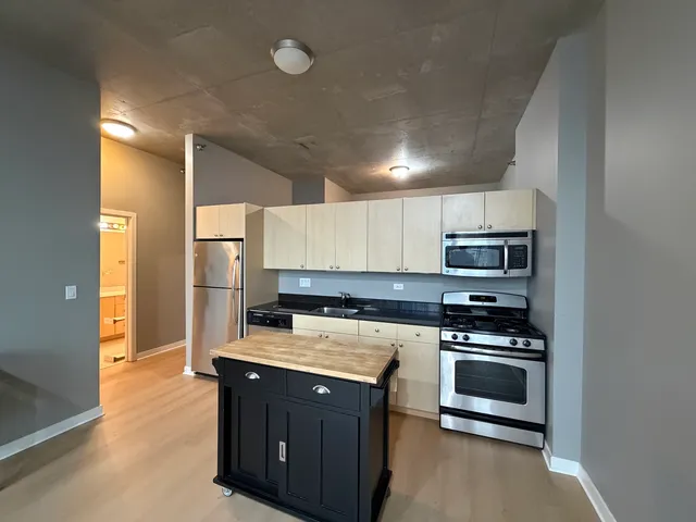 a kitchen with stainless steel appliances a stove a sink and a refrigerator