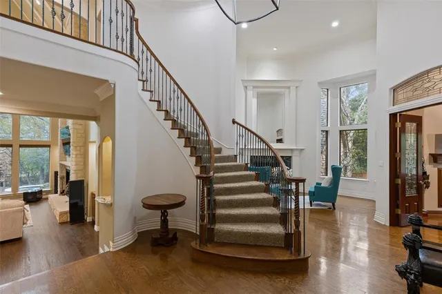 a view of entryway and hall with wooden floor and windows