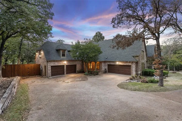 a front view of a house with yard and trees