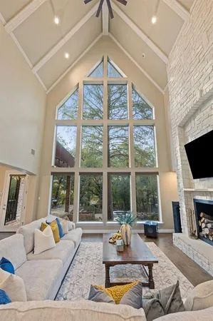 a living room with furniture a flat screen tv and a large window