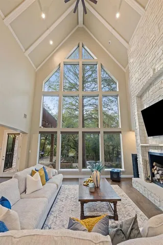 a living room with furniture a flat screen tv and a large window