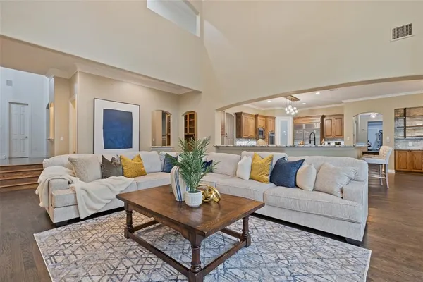 a living room with furniture potted plant and view of kitchen