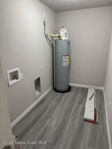 a view of water heater room with wooden floor