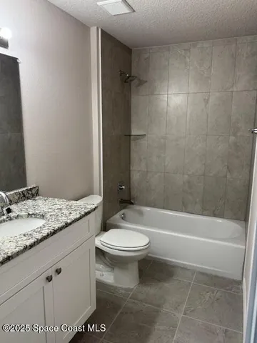 a bathroom with a granite countertop toilet a sink and a bathtub