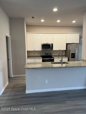 a kitchen with stainless steel appliances granite countertop a stove a sink and a microwave