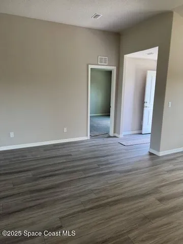 a view of wooden floor and cabinets in a room
