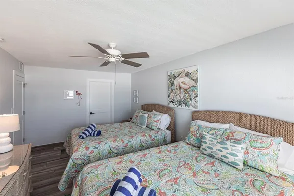 a bedroom with two beds and a lamp on the dresser