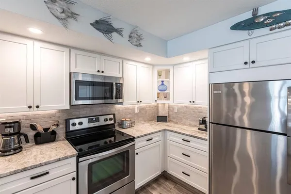 a kitchen with white cabinets and stainless steel appliances