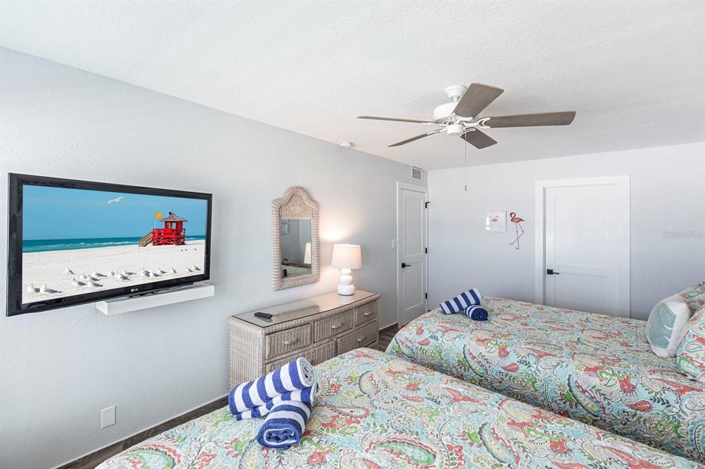 6154 Midnight Pass Road, Unit 202 Sarasota, FL 34242 - Photo 6 of 26 a bedroom with a bed and a chandelier