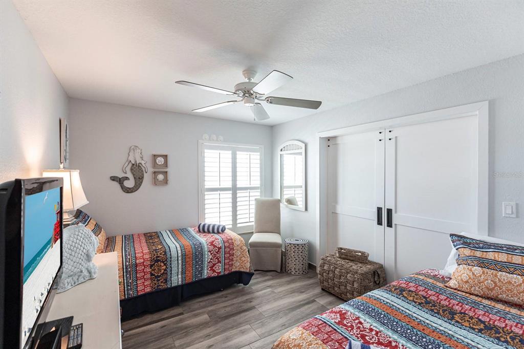6154 Midnight Pass Road, Unit 202 Sarasota, FL 34242 - Photo 8 of 26 a bedroom with a large bed and a chandelier