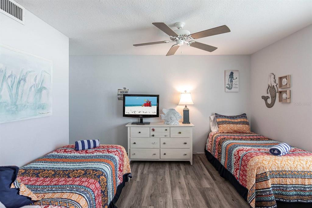 6154 Midnight Pass Road, Unit 202 Sarasota, FL 34242 - Photo 10 of 26 a bedroom with a bed and a chandelier