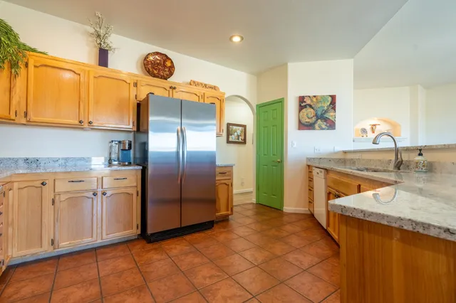 a kitchen with stainless steel appliances granite countertop a sink and a refrigerator