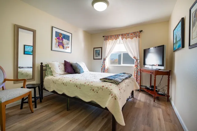 a bedroom with a bed and a flat screen tv