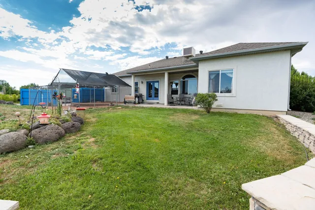 a view of a house with a yard and sitting area