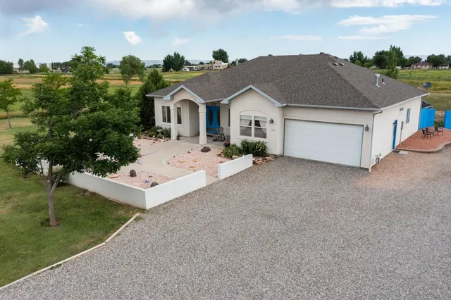 a view of house with garden and tall tress