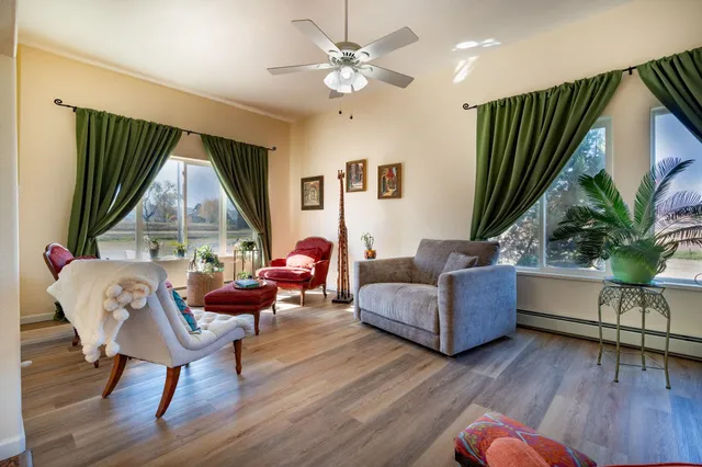 a living room with furniture a window and wooden floor