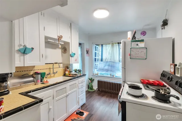 a kitchen with a sink cabinets and wooden floor
