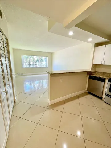 a view of a kitchen with an empty space and a window