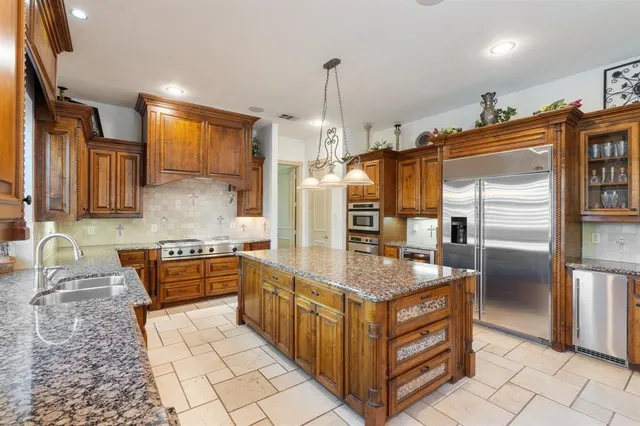 a kitchen island with granite countertop a sink and cabinets