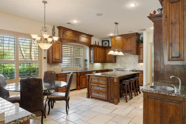 a kitchen with stainless steel appliances granite countertop a stove a sink dishwasher and a wooden cabinets