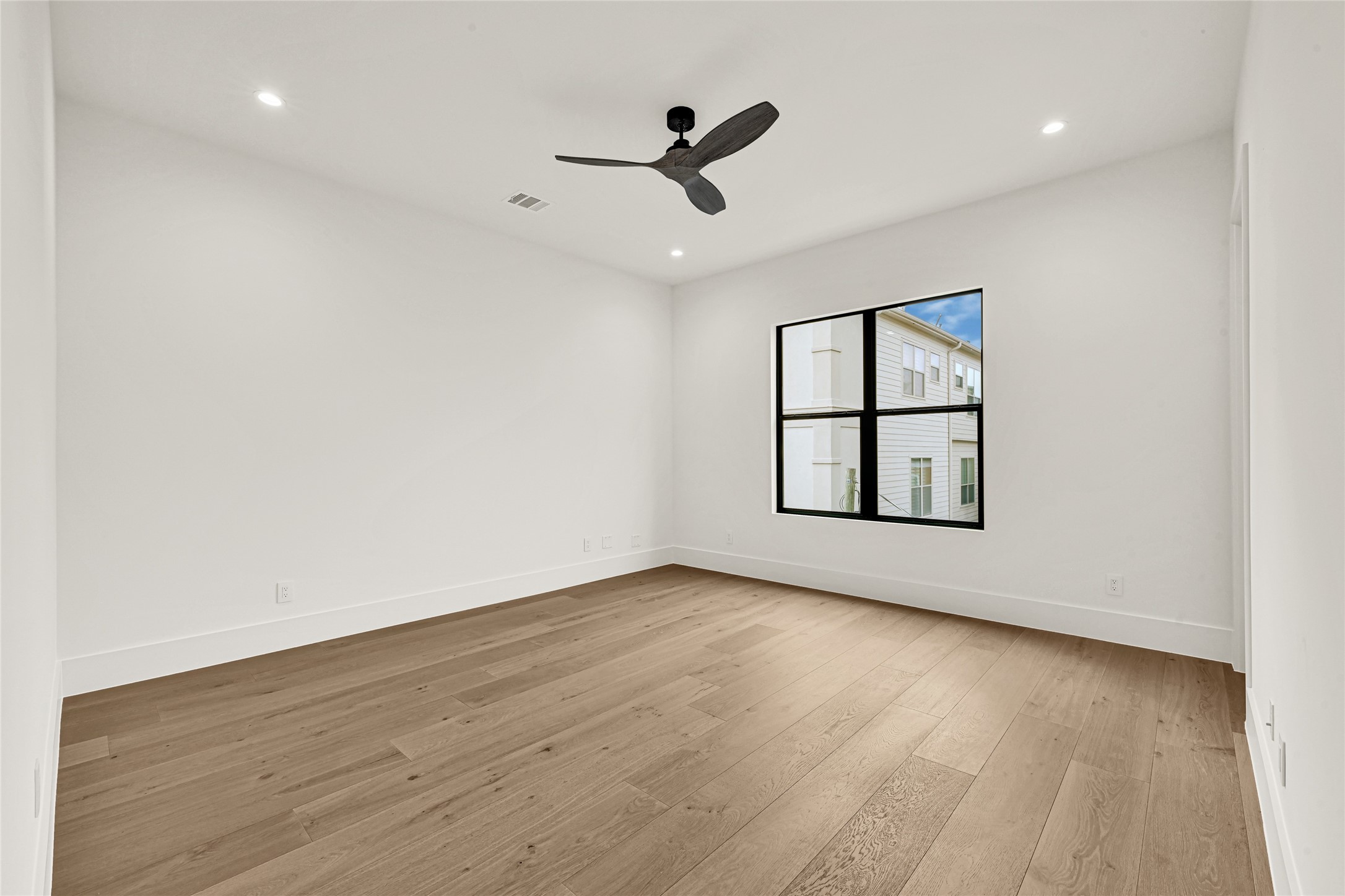 6405 Rodrigo Street, Unit A Houston, TX 77007 - Photo 18 of 28 an empty room with wooden floor ceiling fan and windows