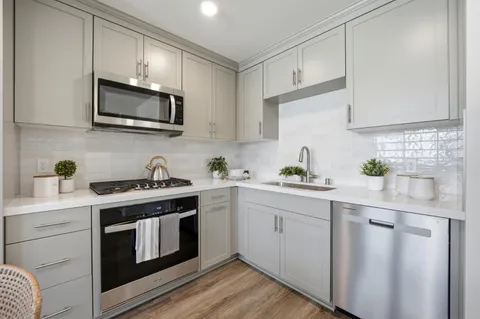 a kitchen with white cabinets stainless steel appliances and sink