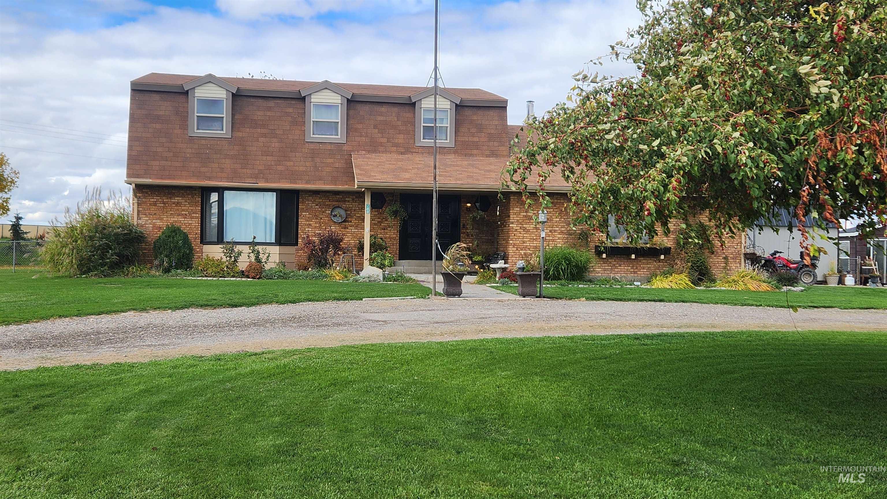 View of front of house featuring brick siding, roof with shingles, and a front lawn