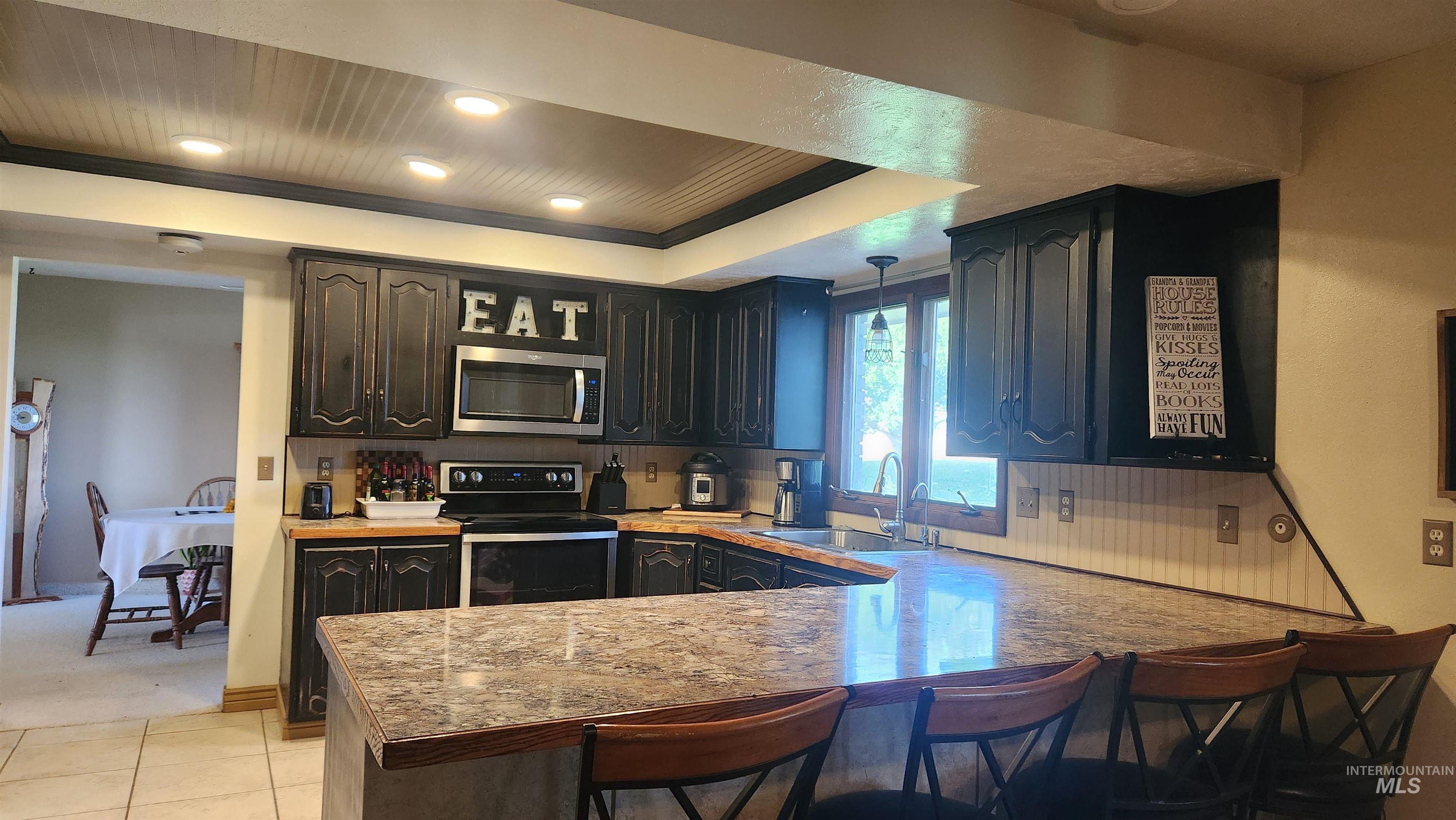 288 South 123 West Burley, ID 83318 - Photo 15 of 36 Kitchen with a kitchen breakfast bar, electric range, pendant lighting, a peninsula, and stainless steel microwave