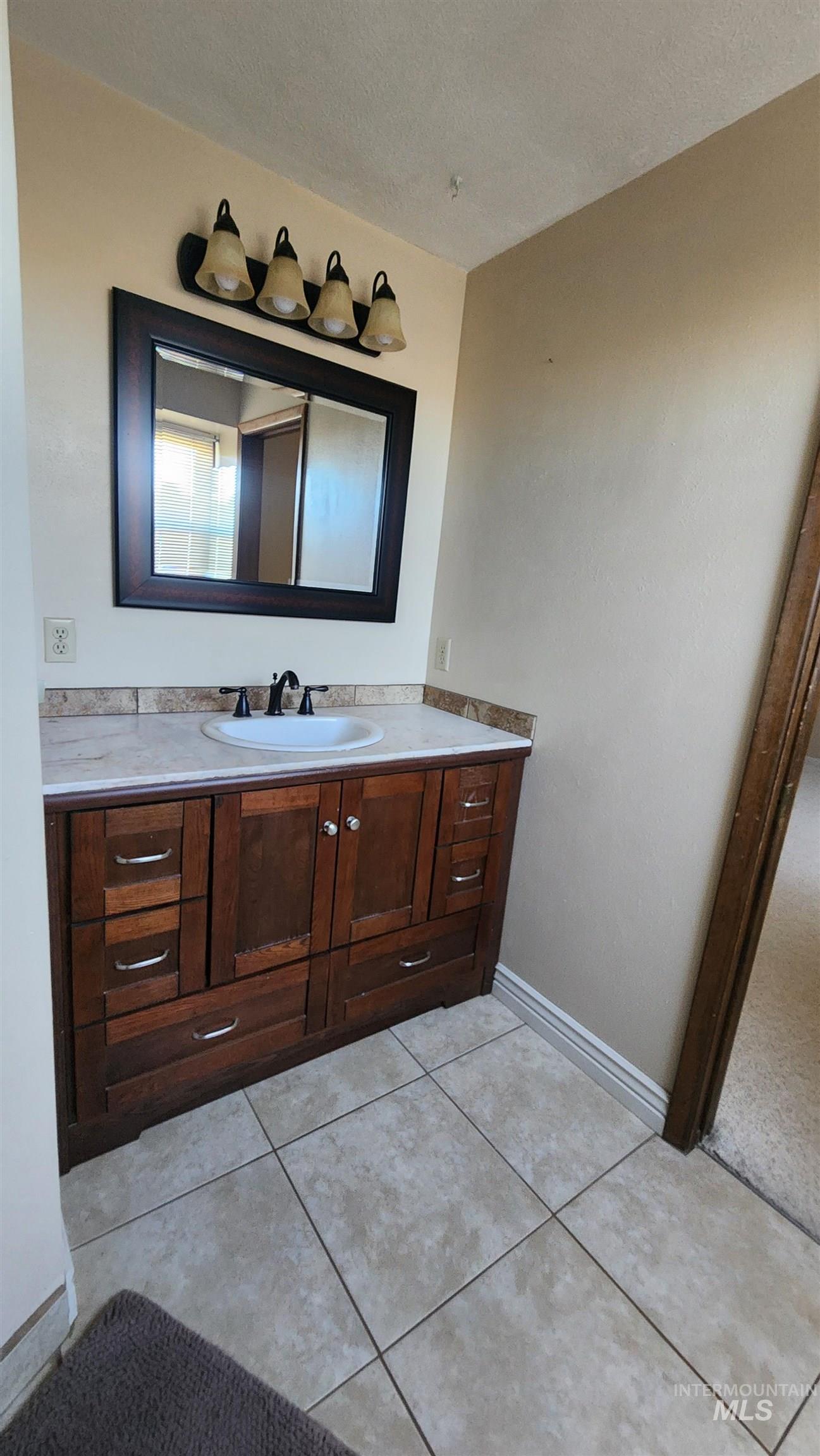 288 South 123 West Burley, ID 83318 - Photo 21 of 36 Bathroom featuring vanity, a textured ceiling, and light tile patterned flooring