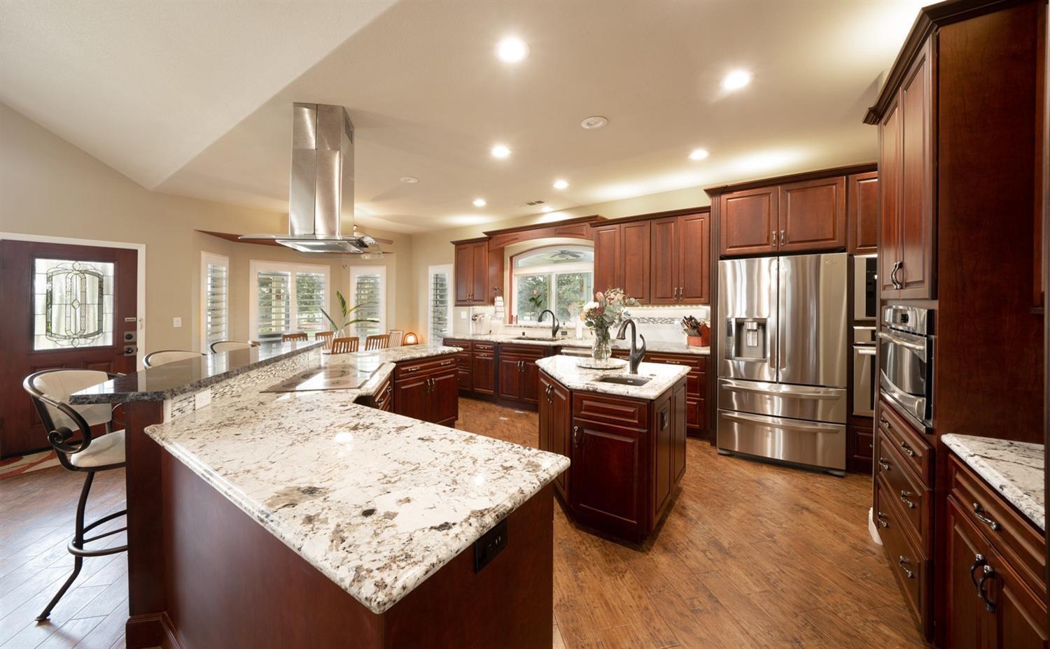 1290 North Applegate Avenue Fresno, CA 93737 - Photo 11 of 65 a kitchen with stainless steel appliances granite countertop a table chairs and a refrigerator