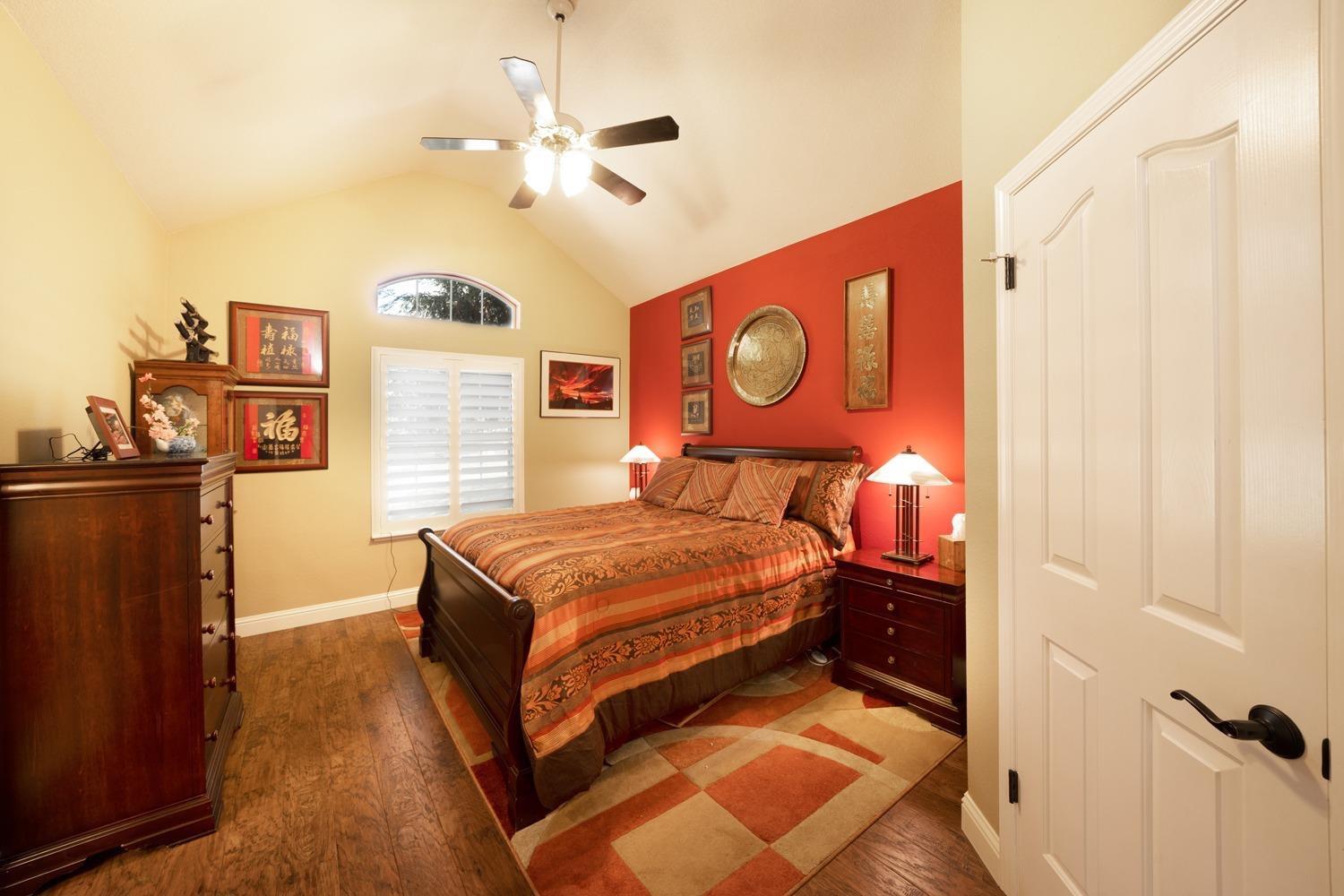 1290 North Applegate Avenue Fresno, CA 93737 - Photo 21 of 65 a bedroom with a bed and a chandelier