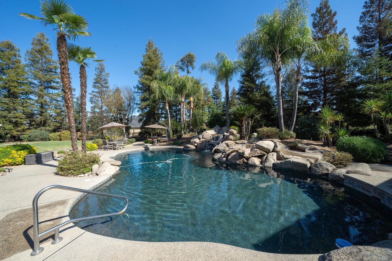 1290 North Applegate Avenue Fresno, CA 93737 - Photo 31 of 65 a view of swimming pool with lawn chairs and a fire pit
