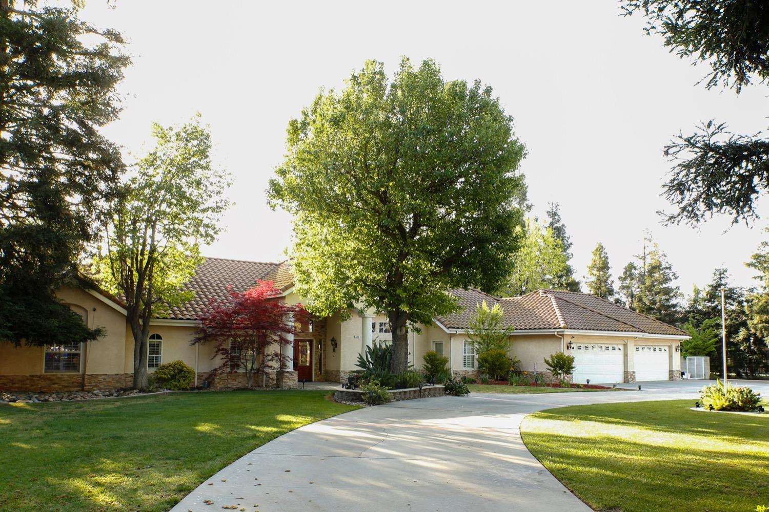 1290 North Applegate Avenue Fresno, CA 93737 - Photo 57 of 65 a front view of a house with a garden and trees