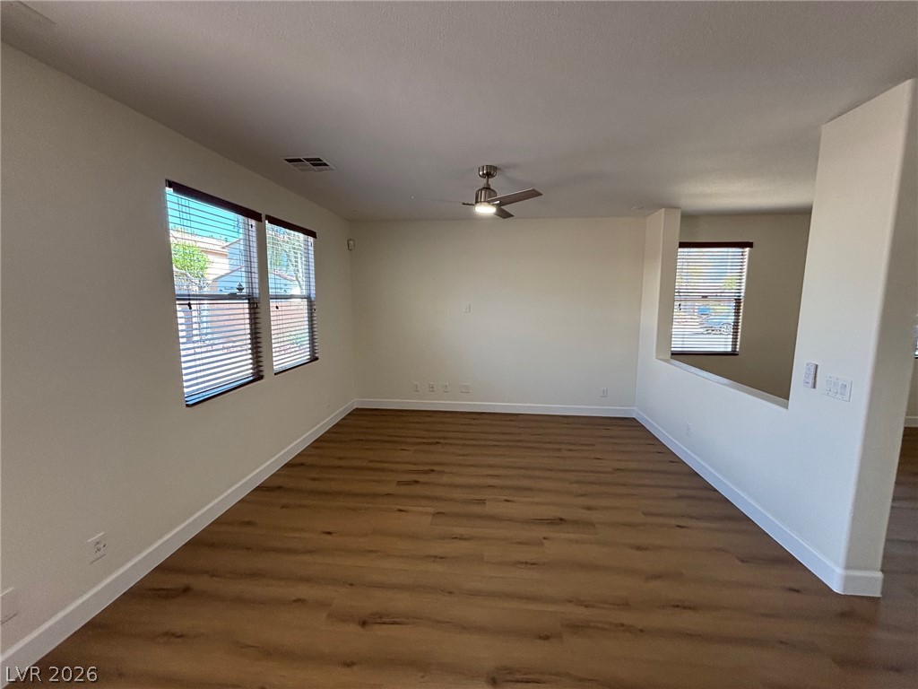 4900 Naff Ridge Drive Las Vegas, NV 89131 - Photo 6 of 21 A versatile living space with rich wood-look flooring and multiple windows awaits your personal touch.