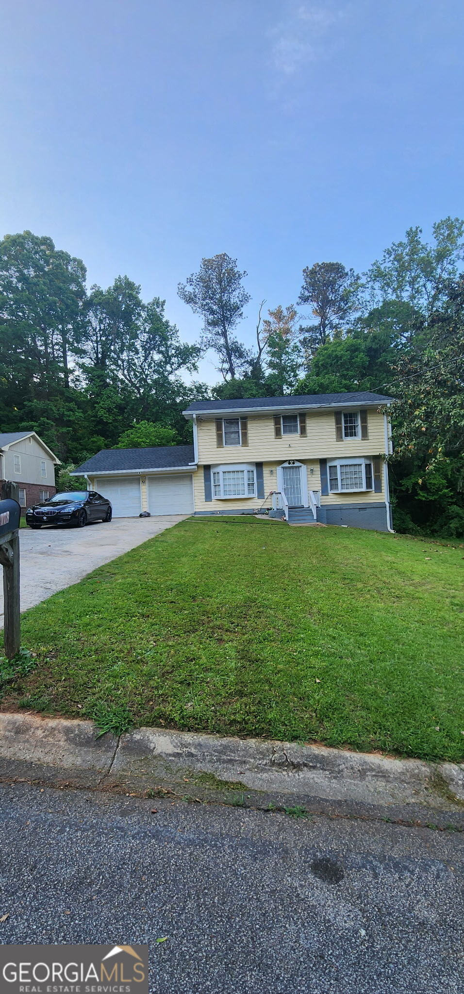 a view of a house with a yard and sitting area